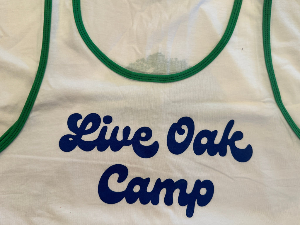 White tank top with 'Live Oak Camp' text in blue on a white background